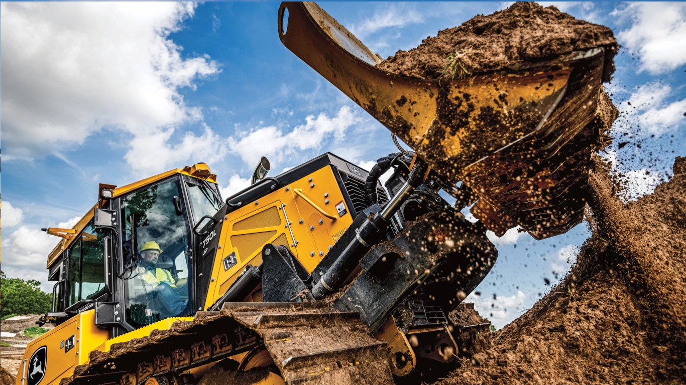 A John Deere 750L Dozer scooping dirt on a worksite. 